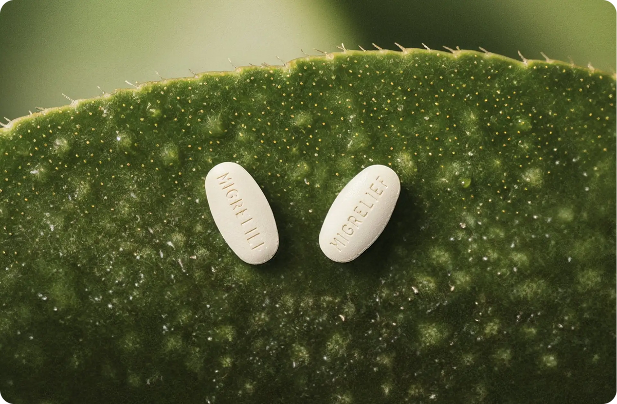 Two MigreLief caplets on a green background